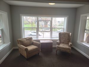 Room in house with lots of windows and armchair furniture