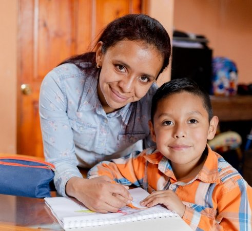 A woman helping a child learn.