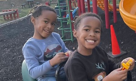 Two smiling children on a playground.