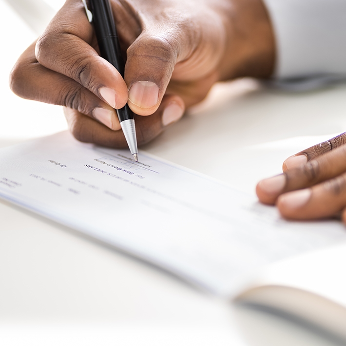 A person writing a donation check.