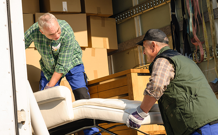 Two workers unloading donations from a truck.