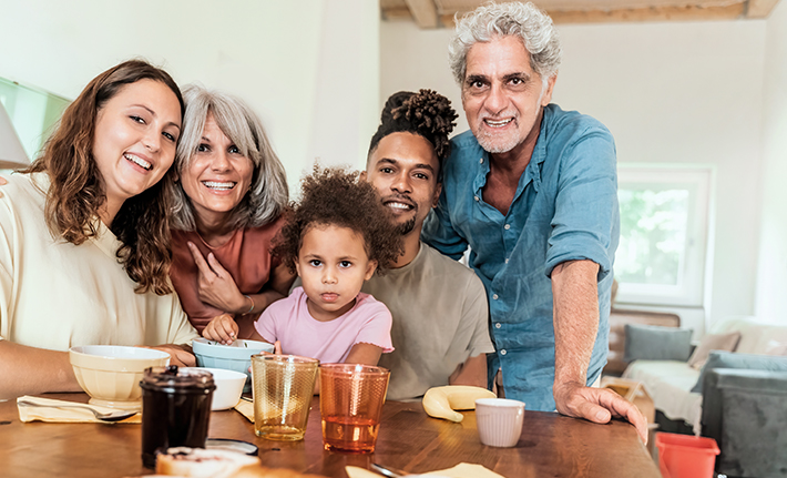A happy family, of 3 generations, take a picture around the table
