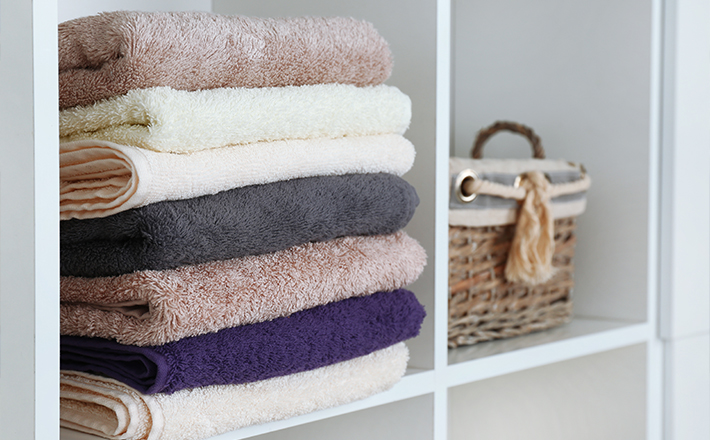 Multi-colored towels stacked in a bathroom.