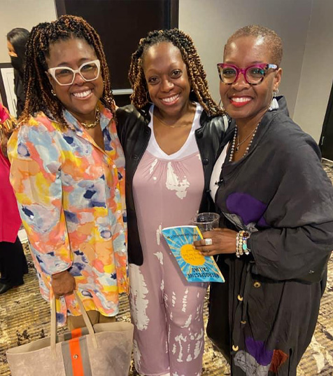 Three smiling women pose for a photograph